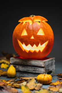 jack o lantern on brown wooden table by Łukasz Nieścioruk courtesy of Unsplash.