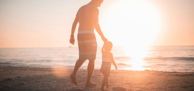 man holding girl heading towards sea by Derek Thomson courtesy of Unsplash.